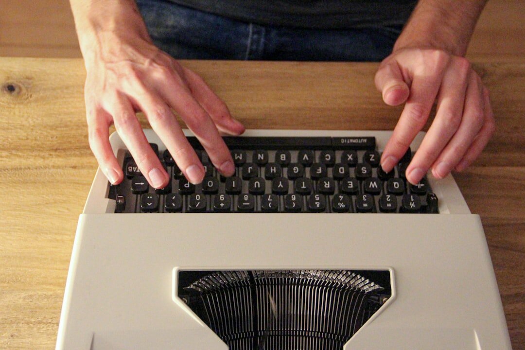 person typing on old typewriter